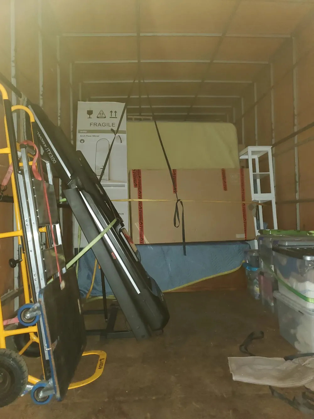 Trolley and mixed household freight strapped inside a truck